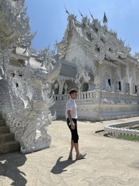 a man standing in front of a white temple